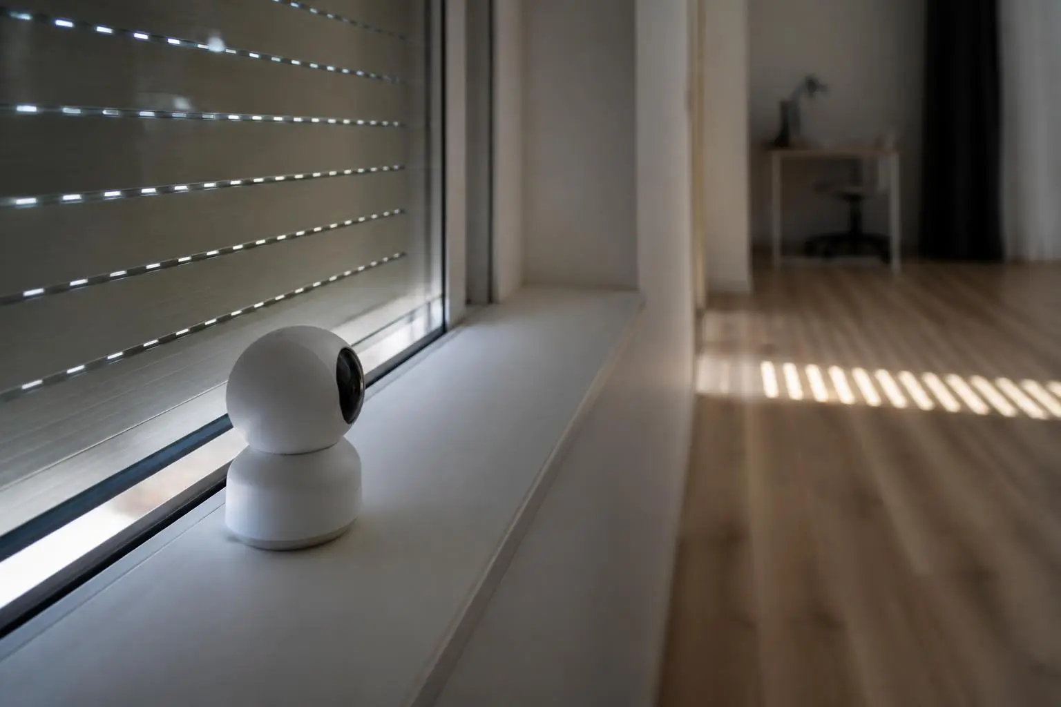 Volet roulant baissé vu de l'intérieur, une petite caméra posée sur l'appui de fenêtre